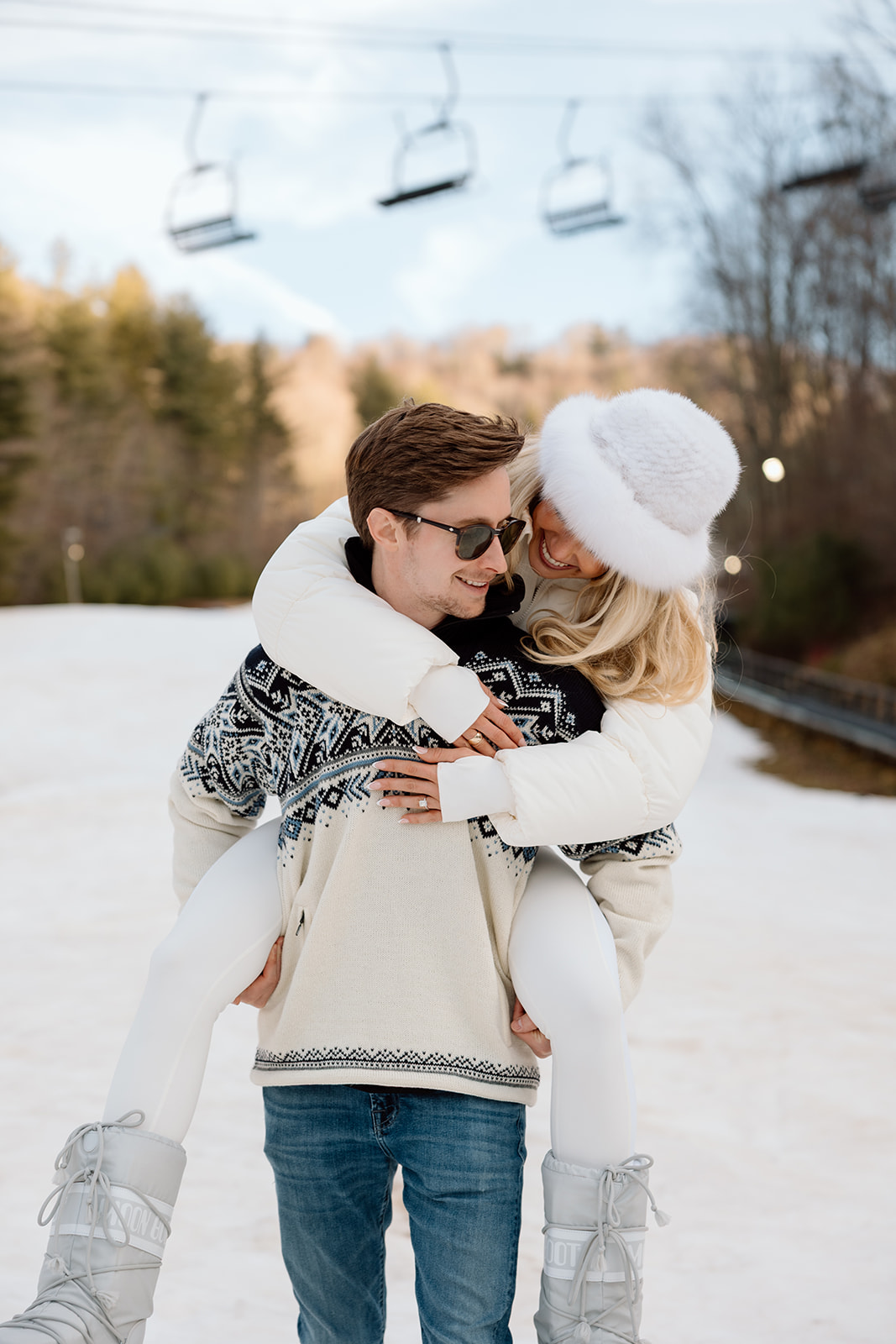 A couple on the snowy slopes beneath the chairlift at Hatley Pointe